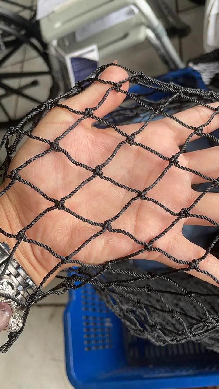 Detalle de la malla negra para mascotas sobre la mano, para ver la luz de malla