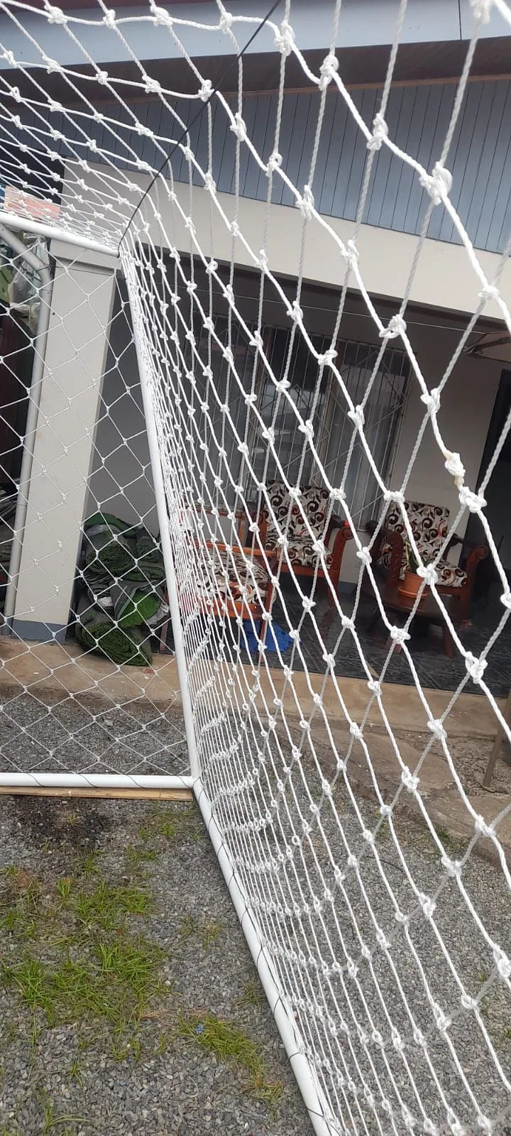 Detalle de la red blanca amarrada al poste del marco