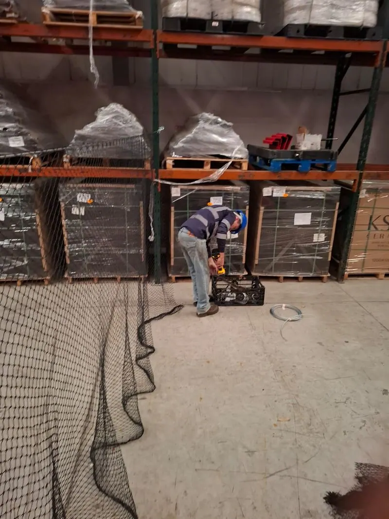El equipo montando la malla durante la jornada de la bodega