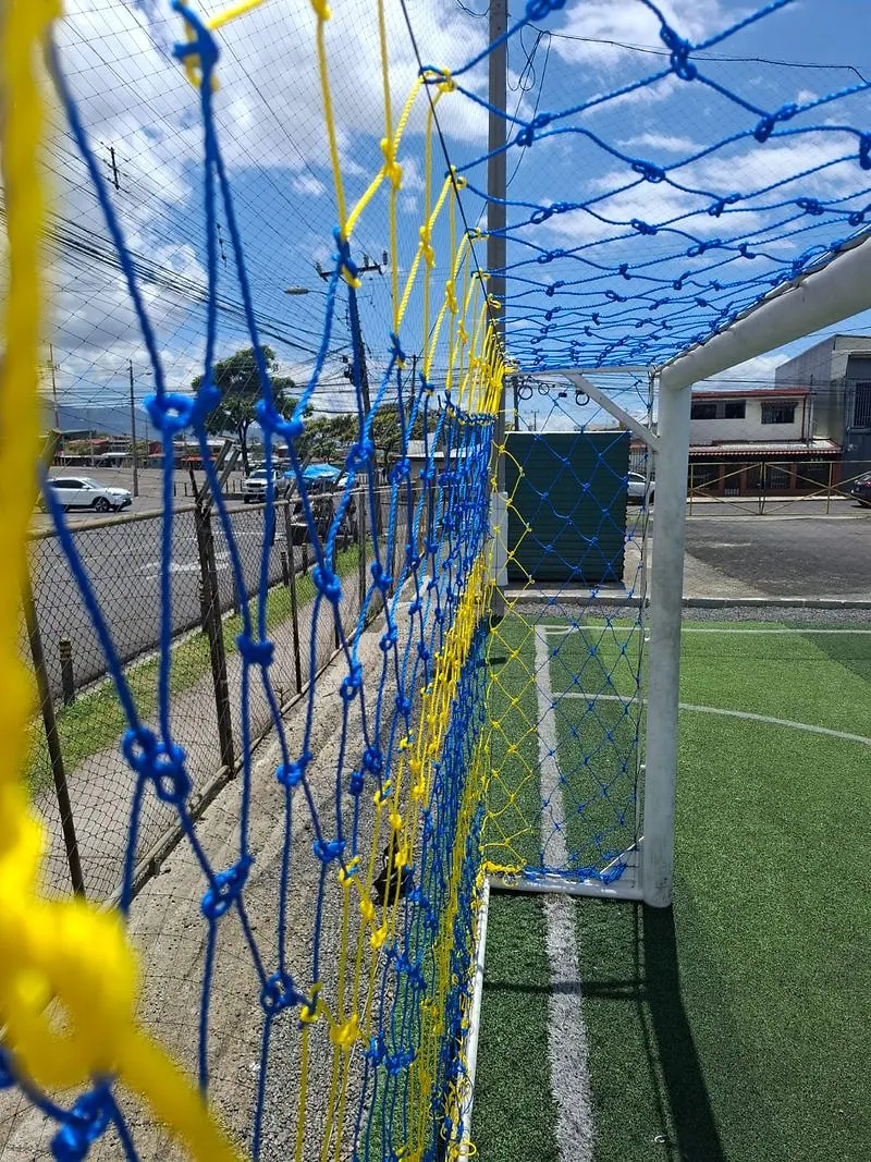 Malla perimetral en dos colores: contiene el balón hacia la calle