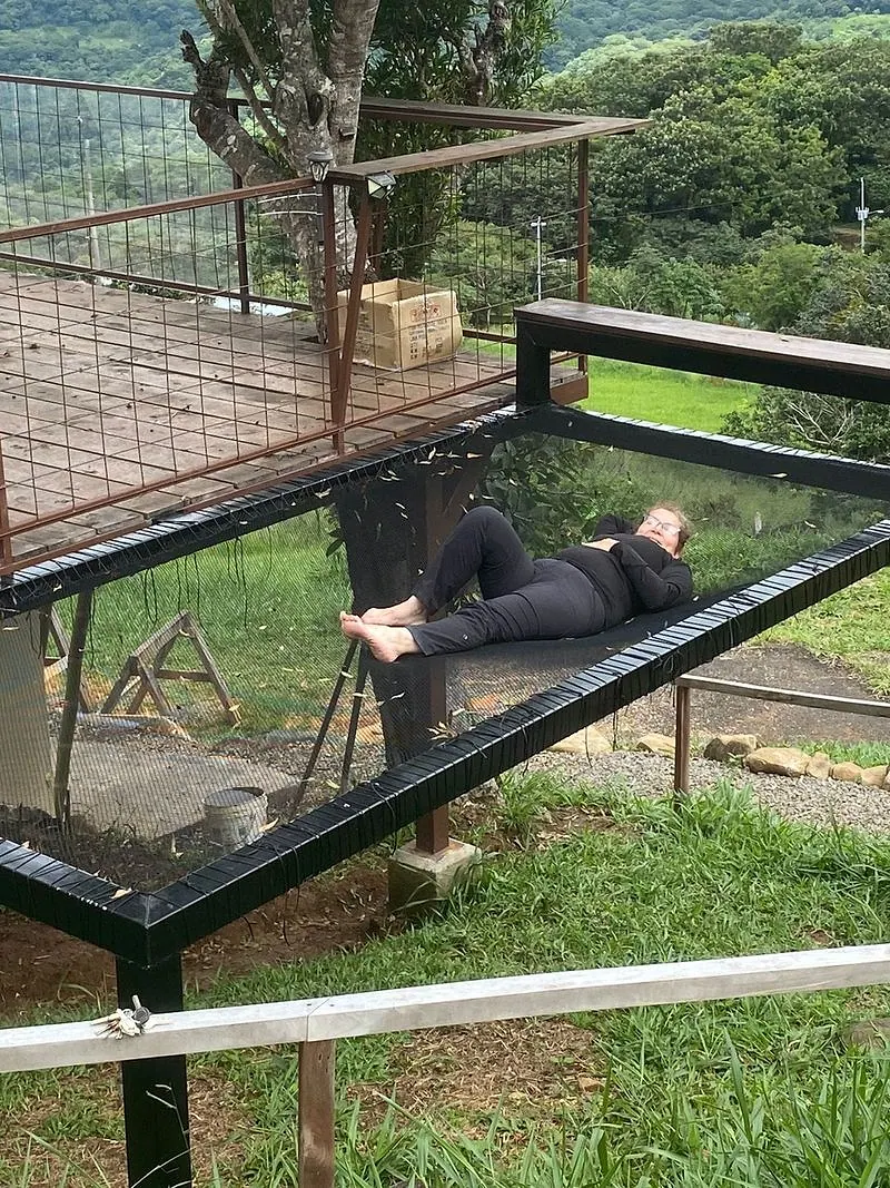 Red de descanso montada en voladizo sobre el terreno, con vista al valle