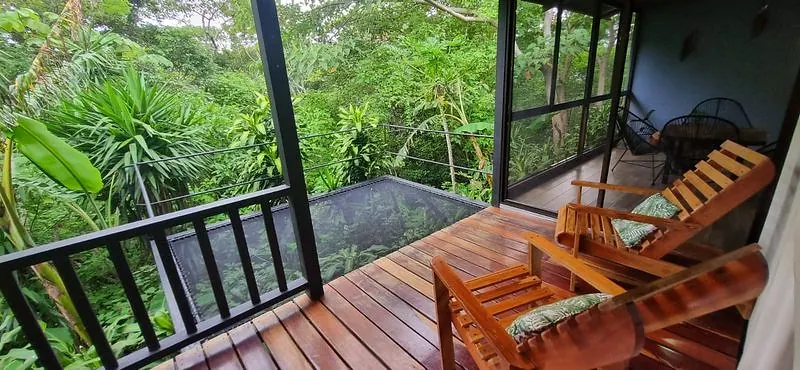 Terraza de madera con la red montada en marco metálico, entre la vegetación